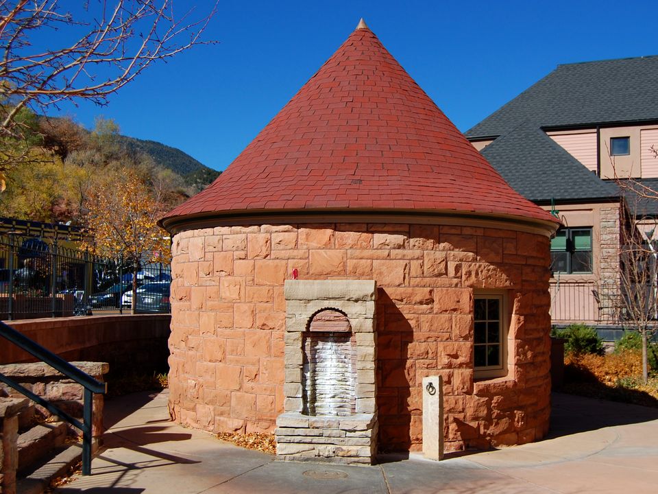 The round sandstone Shoshone Spring house with its red cone roof in Manitou Springs